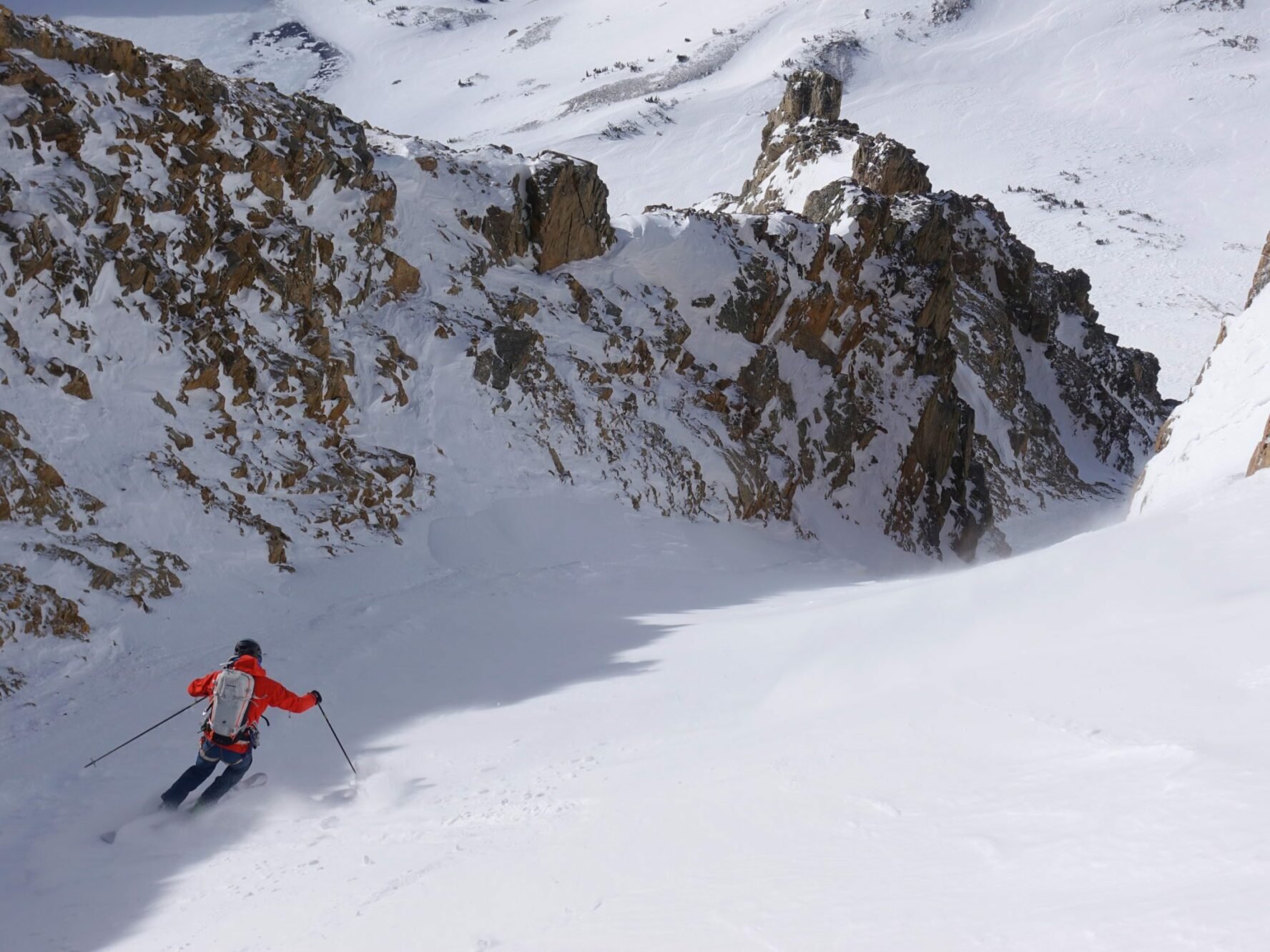 A ski mountaineer is making turns down a powdery couloir ski line in the Tetons.
