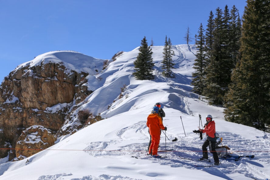 A group of skiers transition to exit out of the resort boundary and into the backcountry.