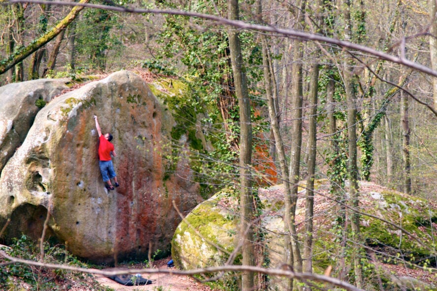 Dude climbing a big rock in France