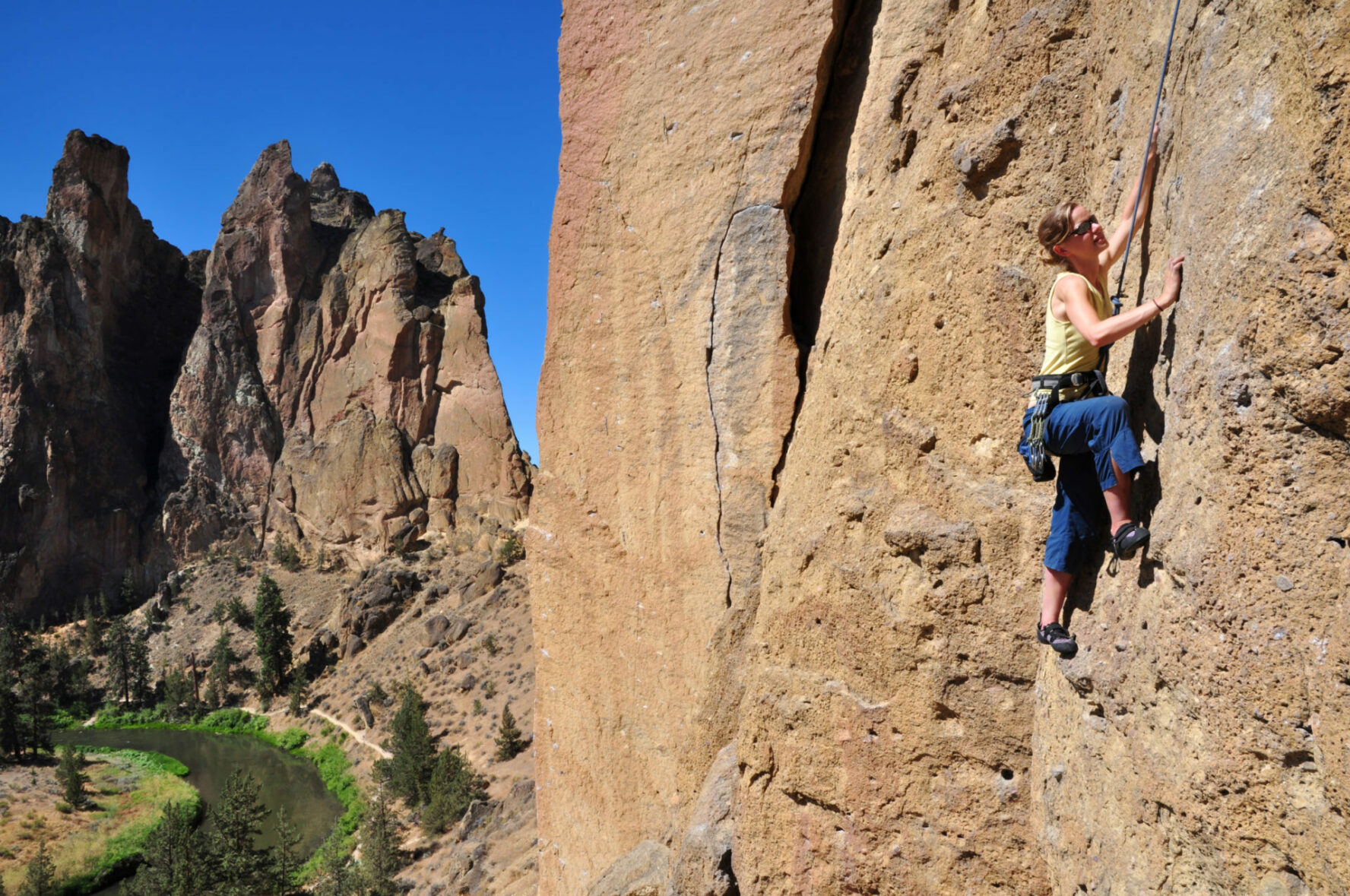 "A woman ascends a cliff at Smith Rock State Park, Oregon."