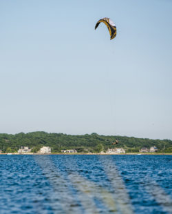 The man exercising kiteboarding and jumping at Lazy Point Bay in Napeague, Suffolk County, Long Island, New York State, USA. The bit 19 square meters kite, slow wind.