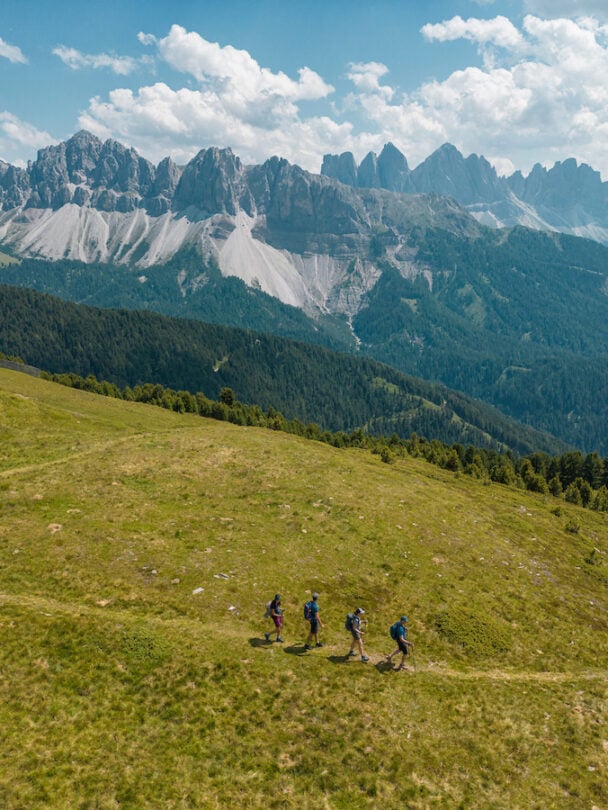 Three climbers valley views Dolomites