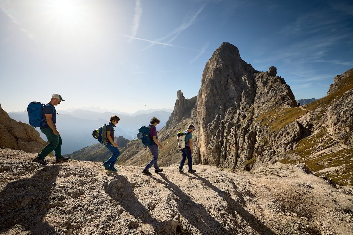 Four hikers Dolomites sunny day