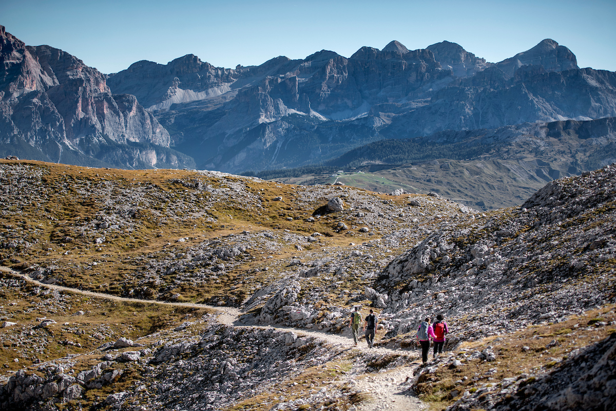 Four hikers on a sunny day Dolomites peaks