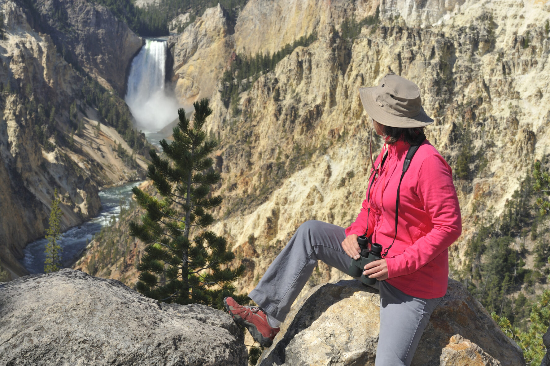 "Woman looking at Lower Falls at Yellowstone National Park, Wyoming, USA."