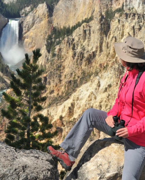 "Woman looking at Lower Falls at Yellowstone National Park, Wyoming, USA."