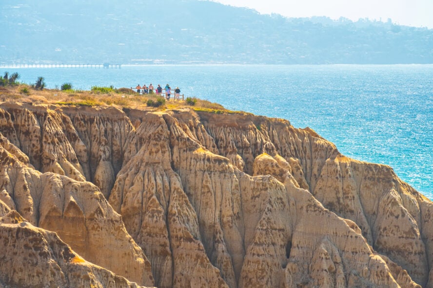 Hikers atop the sandstone cliffs by the ocean at Torrey Pines State Park and Reserve.