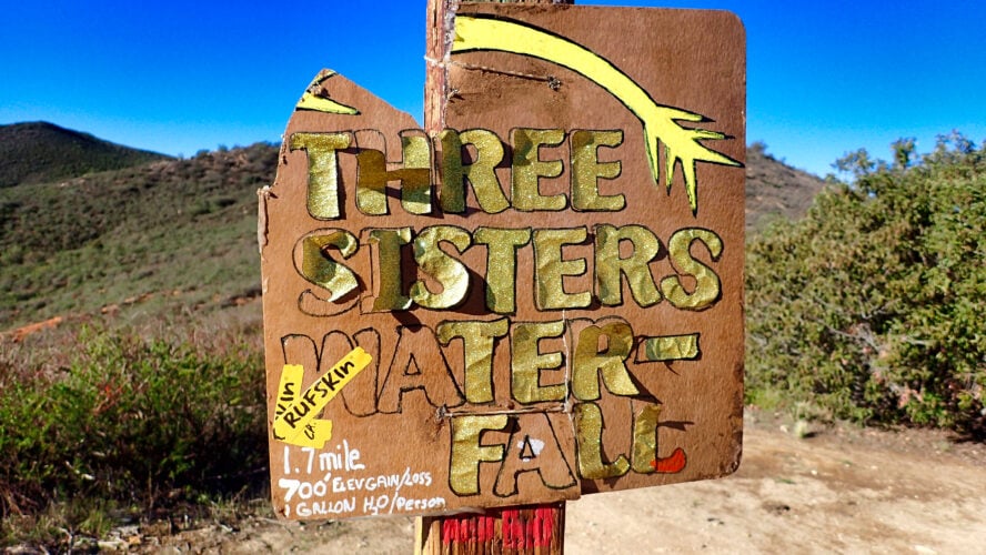 A sign post marking an intersection at Three Sisters Falls warns of the necessity of carrying extra water.