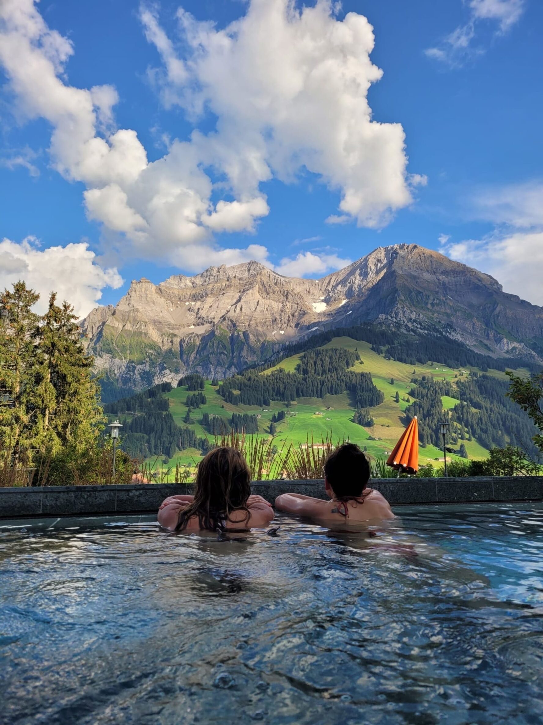 Pool in the Swiss Alps and hikers relaxing
