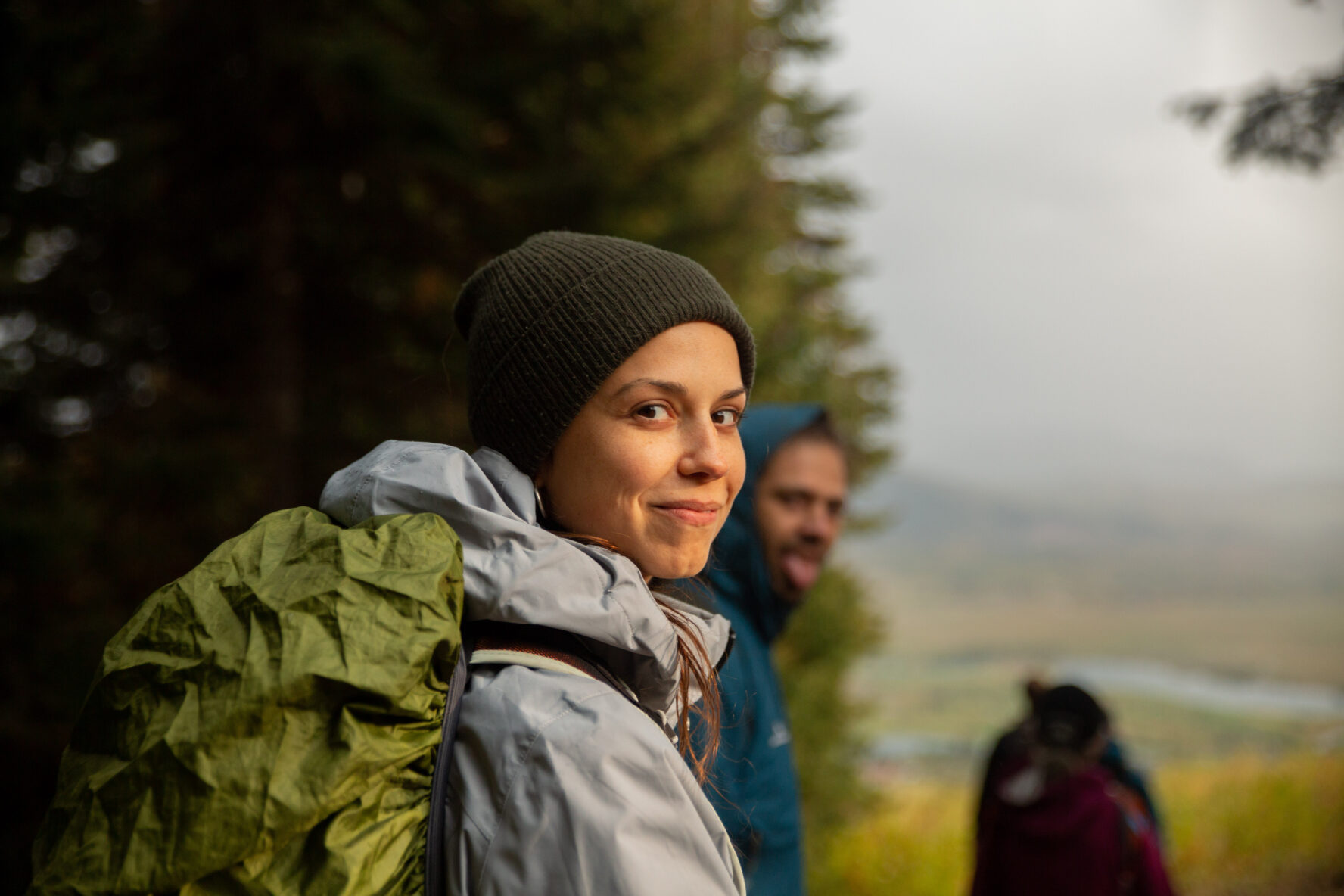 Close up of a person enjoying their hike and more people and nature in the background
