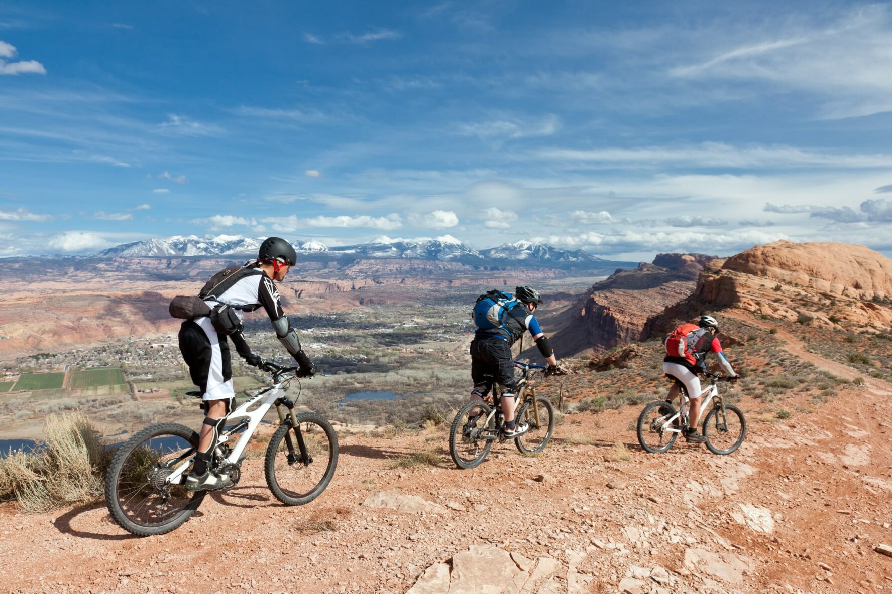 3 people riding a mountain bike in Moab, Utah