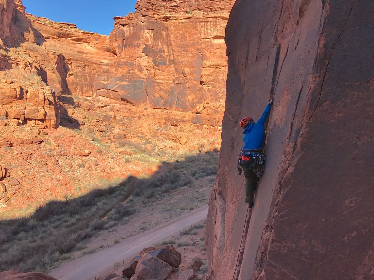 Climber going up a crack in the wall in Moab.