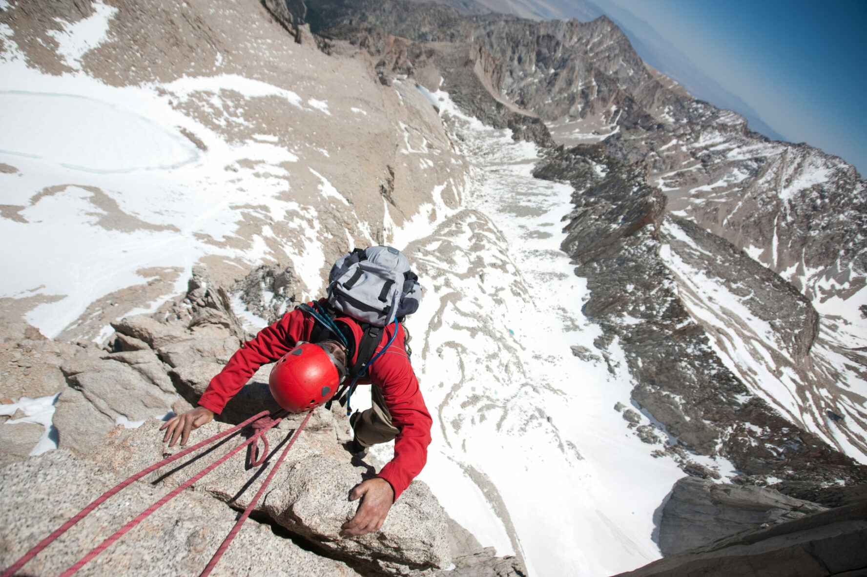 An alpine rock climber is summiting a peak in High SIerra.