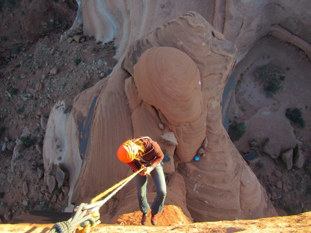 A woman climbing a tower in Moab