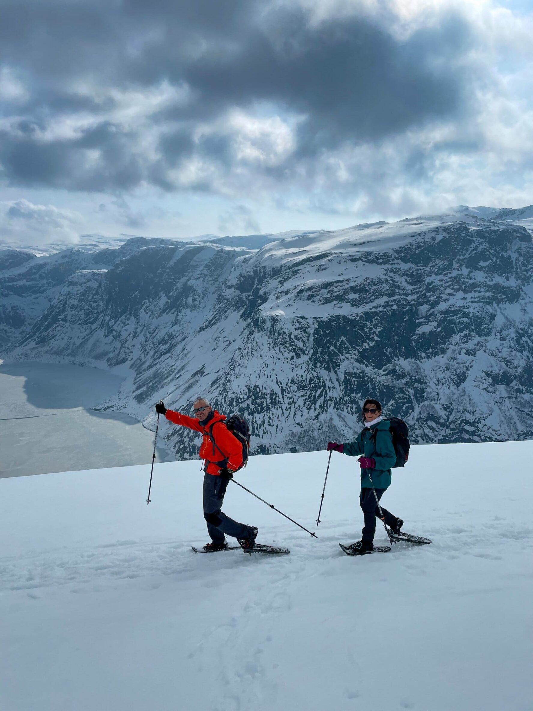 Hikers smiling and snowshoeing on the Trolltunga winter hike