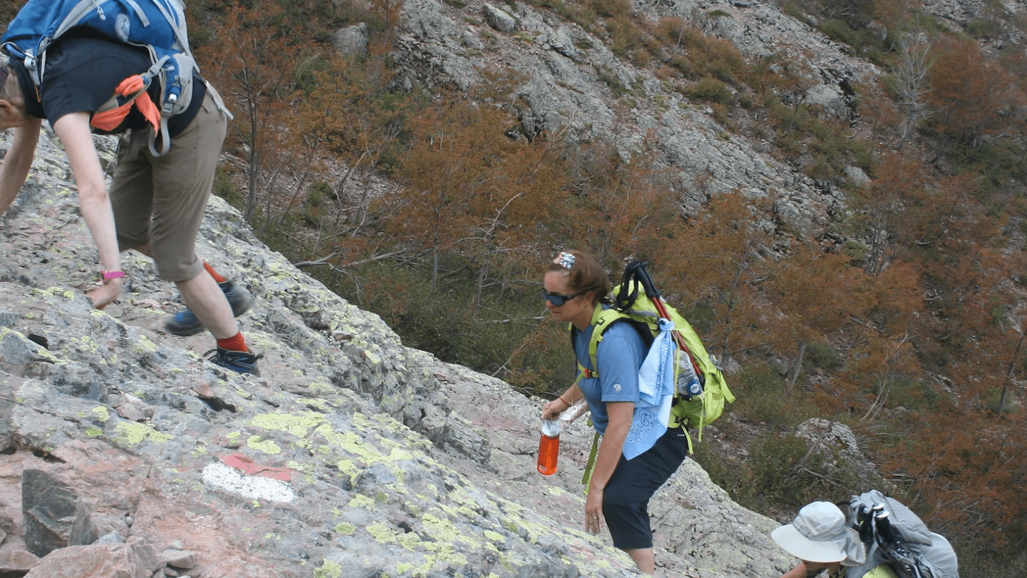 Hikers scrambling in Corsica, France