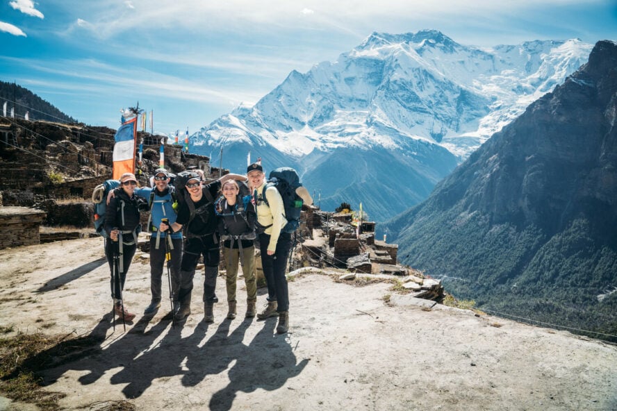 Group of hikers posing in front of the mighty Annapurna range before taking on the Thorung La Pass.