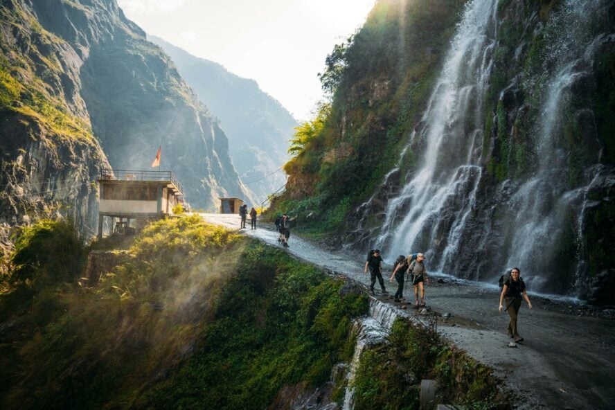 Hikers passing a waterfall on the Annapurna Circuit in Nepal