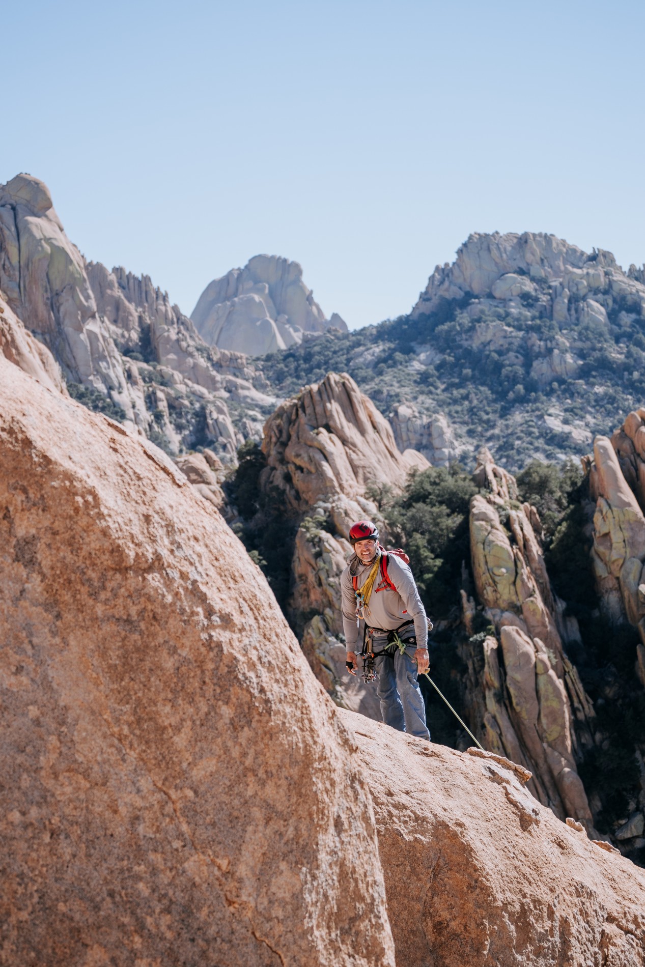 Man smiling while climbing Cochise Stronghold