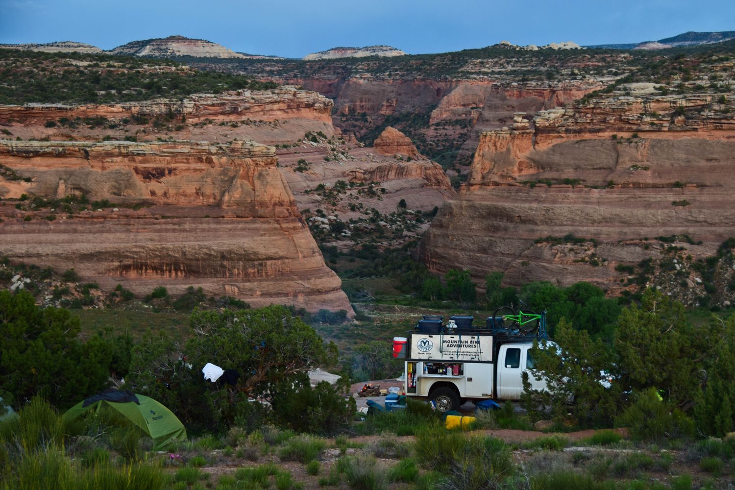 Kokopelli Trail mountain bikers camping near sandstone canyons in Colorado.