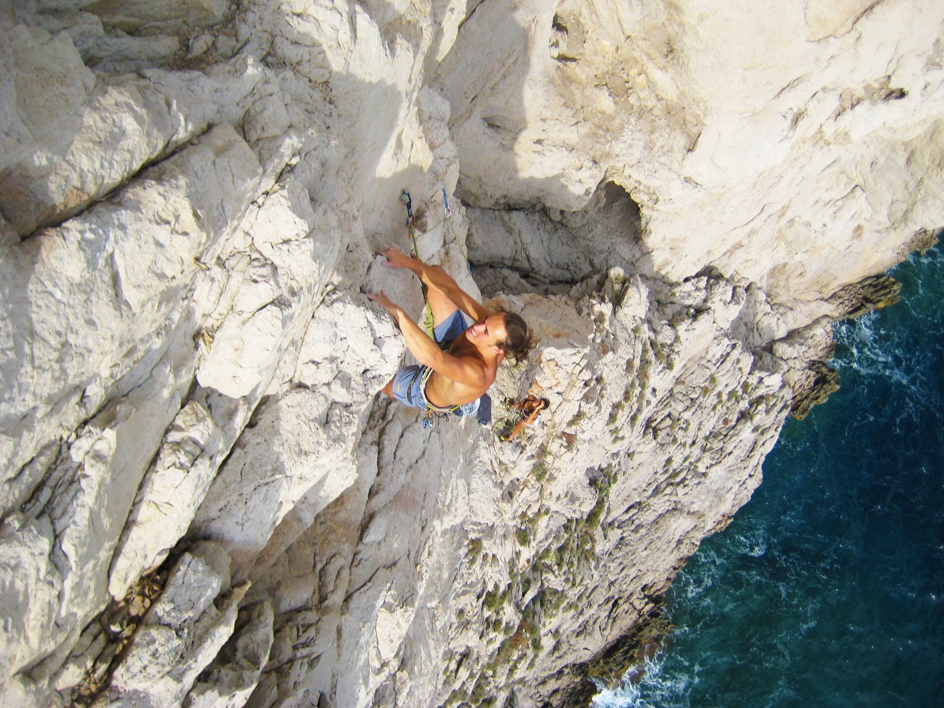 A man sending a route on the coast