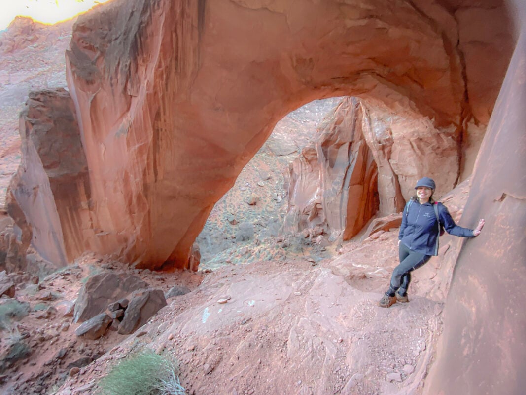 Woman hiking under the Wrather Arch