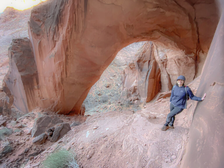 Woman hiking under the Wratch Arch