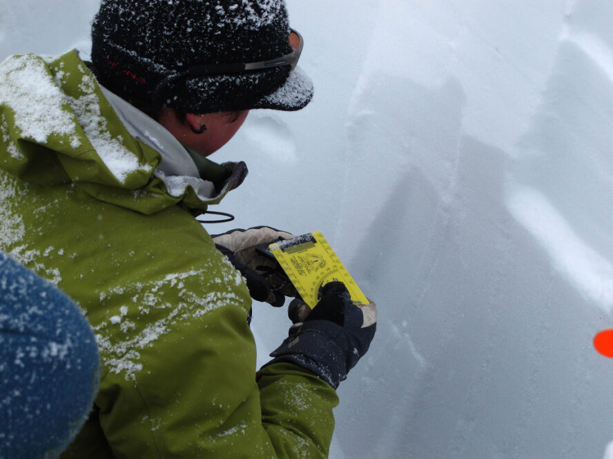 Avalanche Education in Crested Butte, a man measures snow