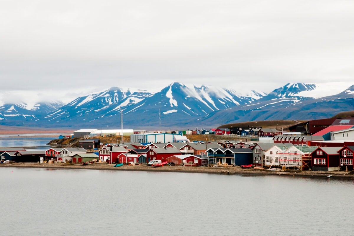 Longyearbyen's colourful houses surrounded by snow and mountains