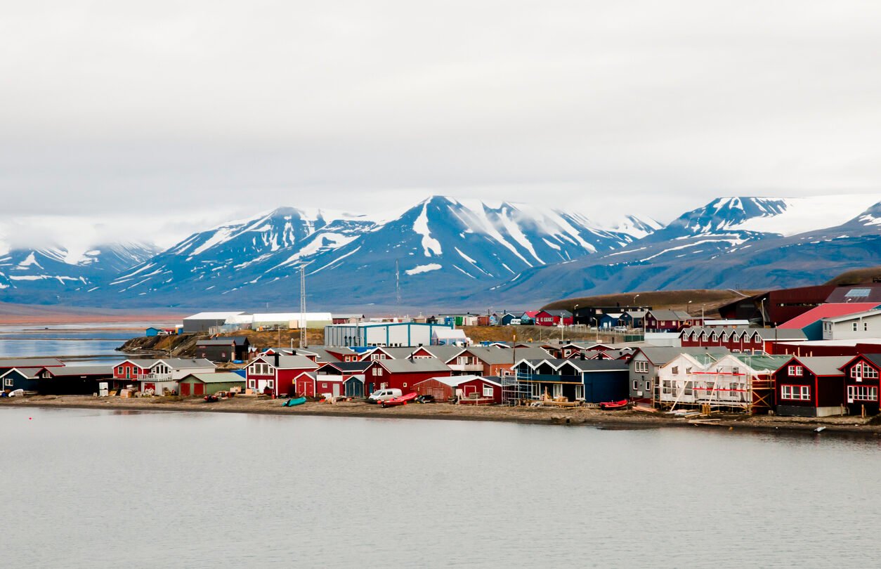 Longyearbyen's colourful houses surrounded by snow and mountains