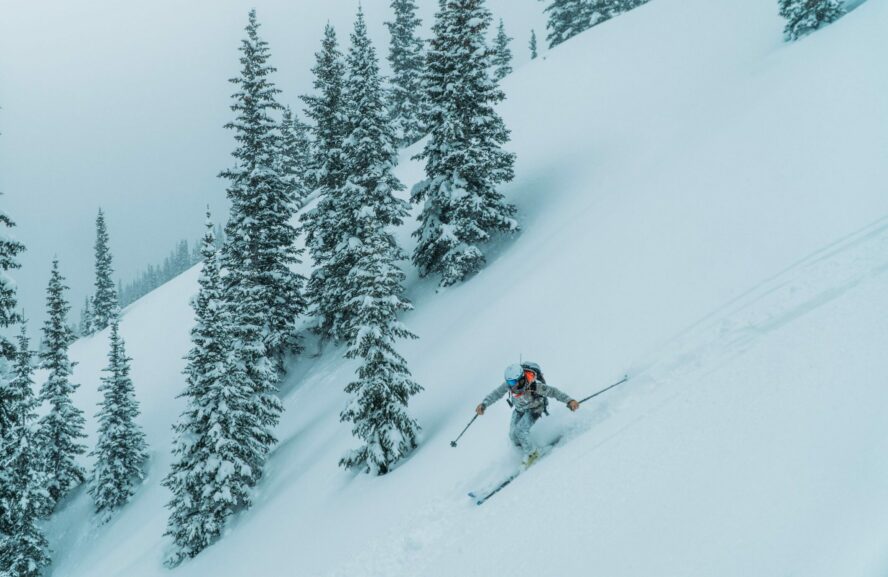 Backcountry skiing downhill on snowy bowls in British Columbia