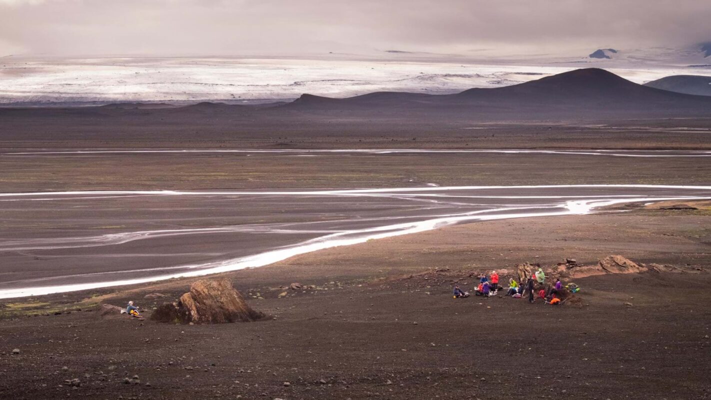 Hikers traversing Iceland’s black sands