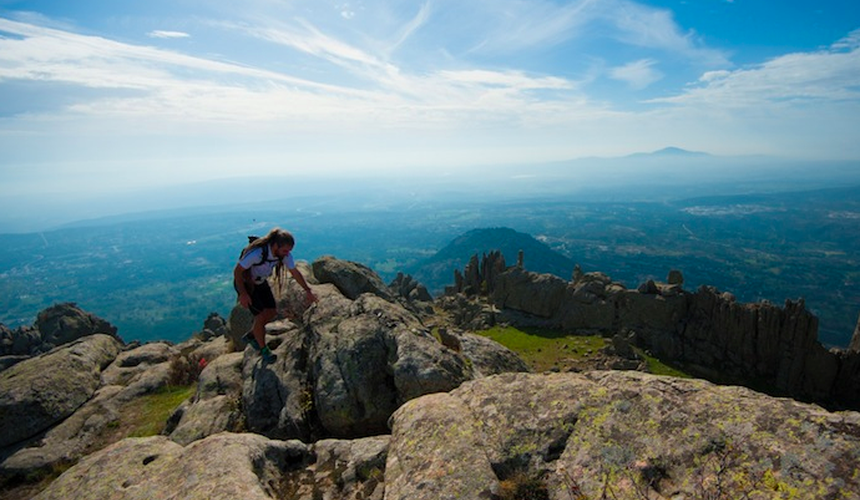 A trail runner on a peak in the Guadarrama Mountains