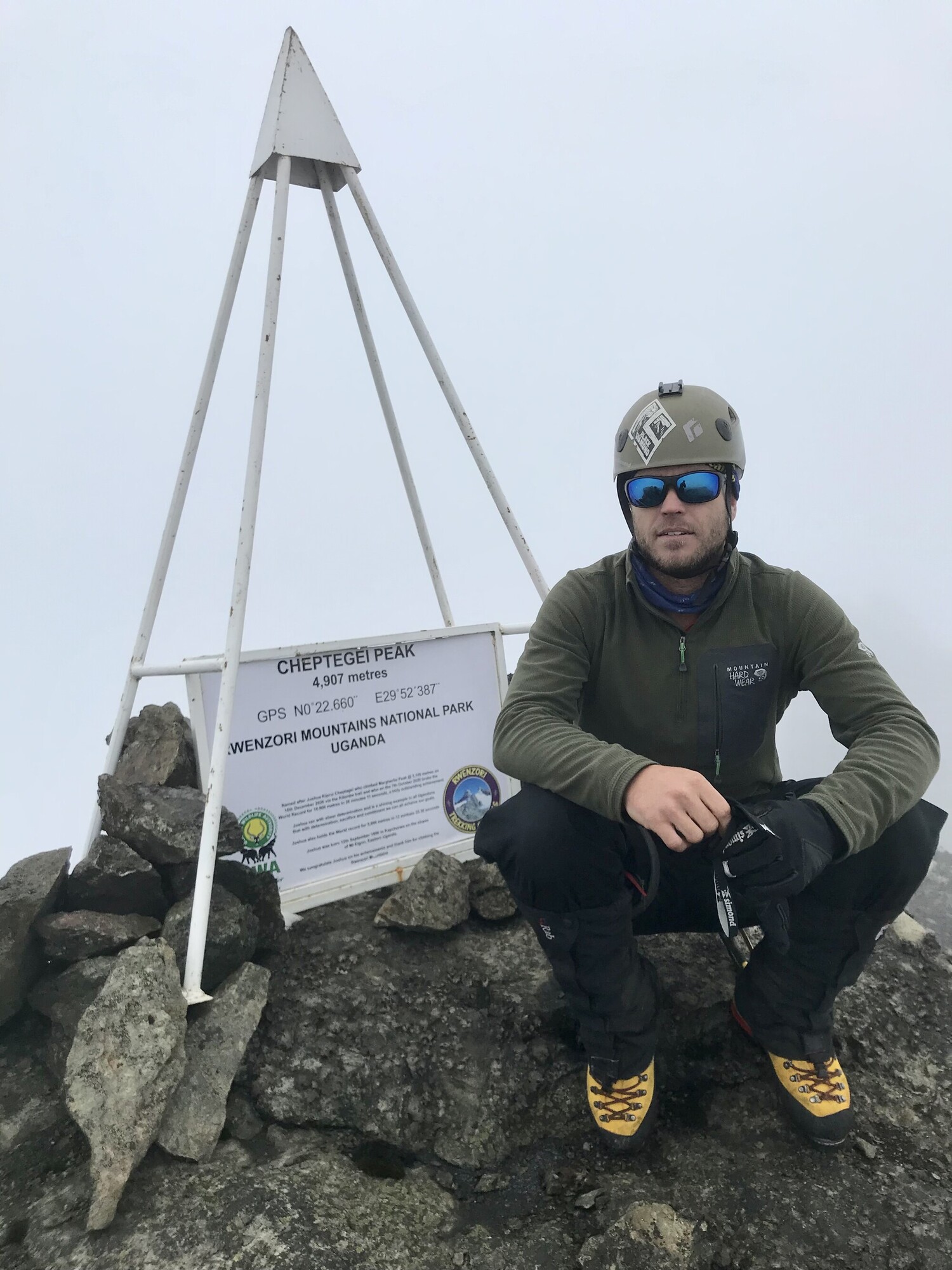 A climber standing next to a peak on Rwenzori