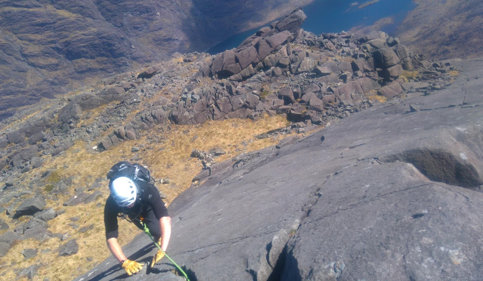 A climber on a cliff in Cuillin Ridge