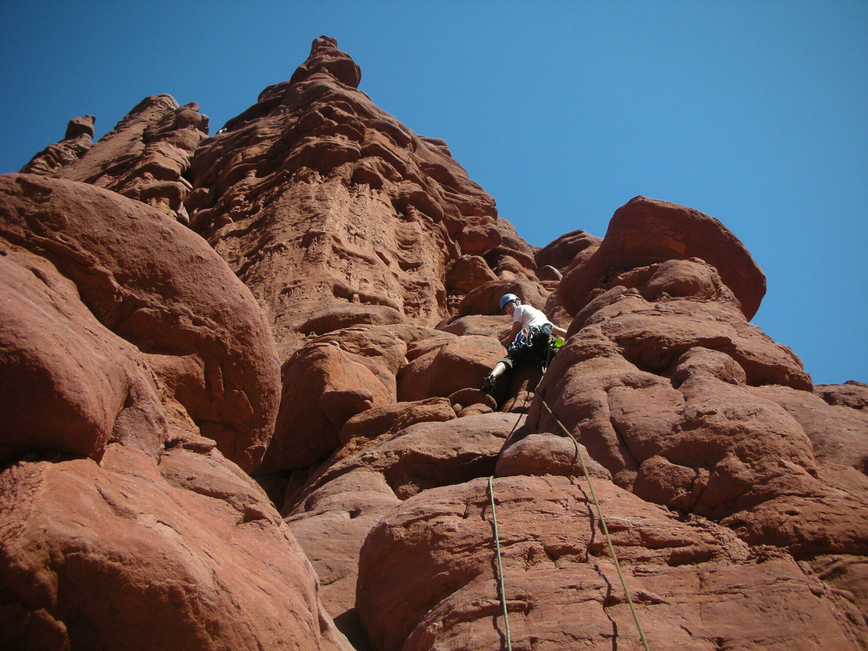 A climber ascending a tower in the Moab region