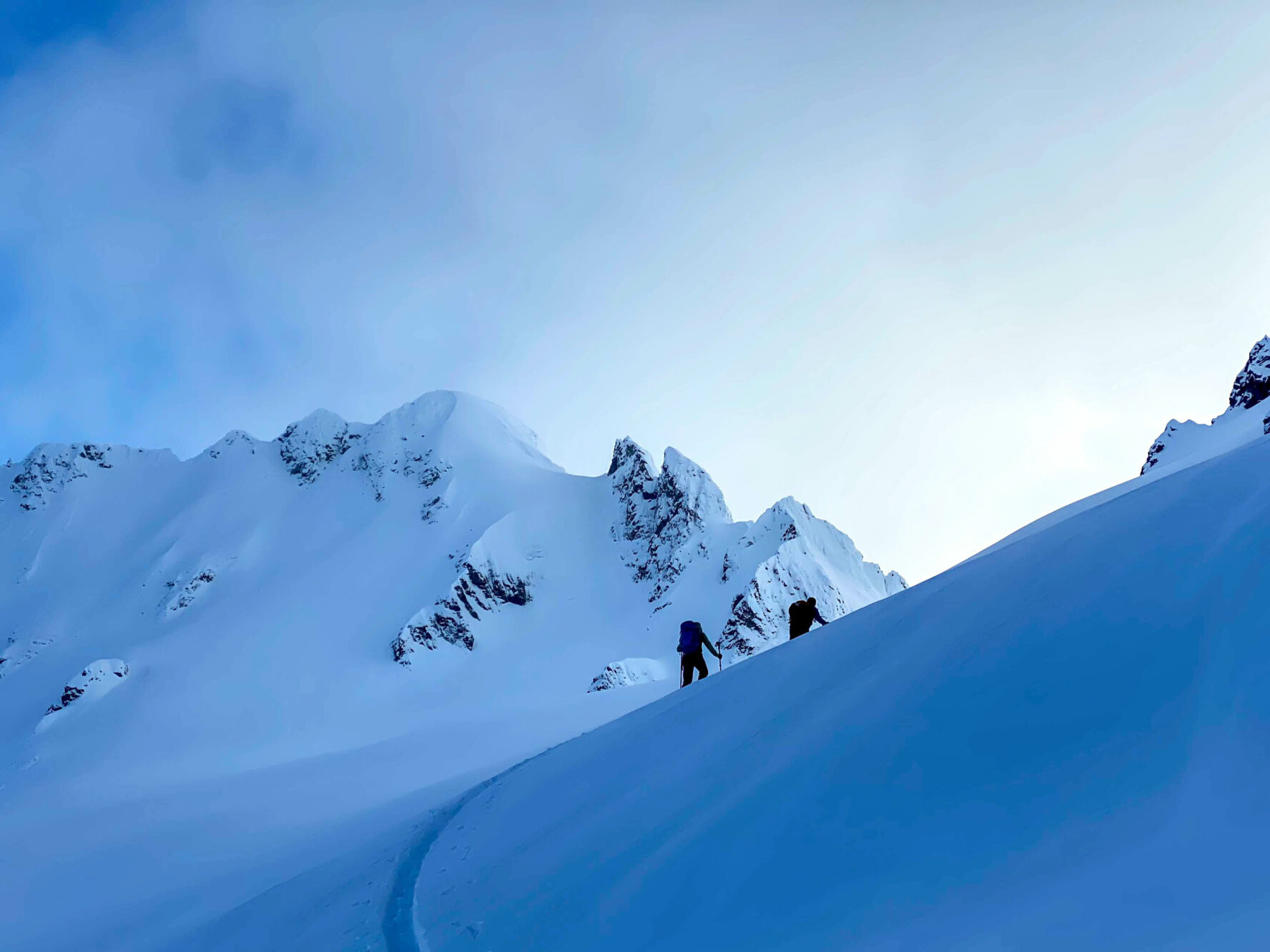 Tourers rounding a slope in the Tantalus Range, BC.