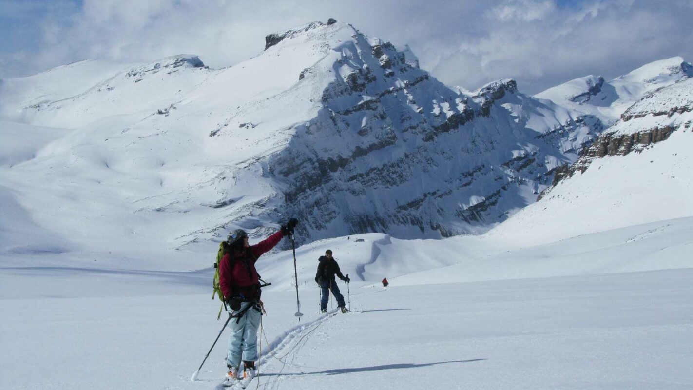 A tourer pointing to a cliff on the Wapta Traverse