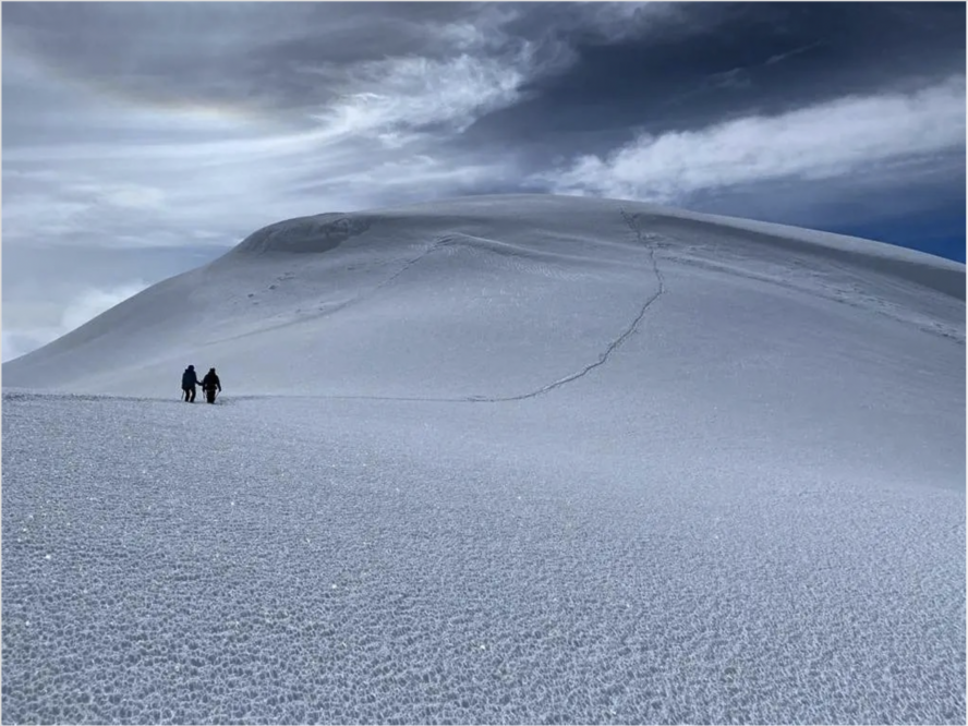 Climbers hiking to Chimborazo’s summit on a cloudy day.