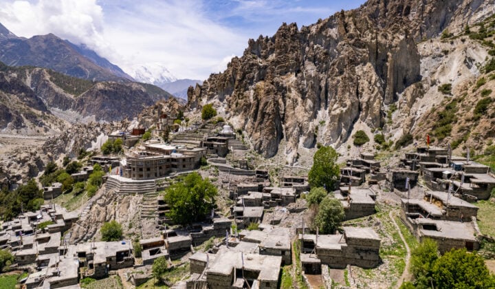 Aerial view of houses and temple on rocky mountains of Mountains somewhere in Nepal against sky during sunny day