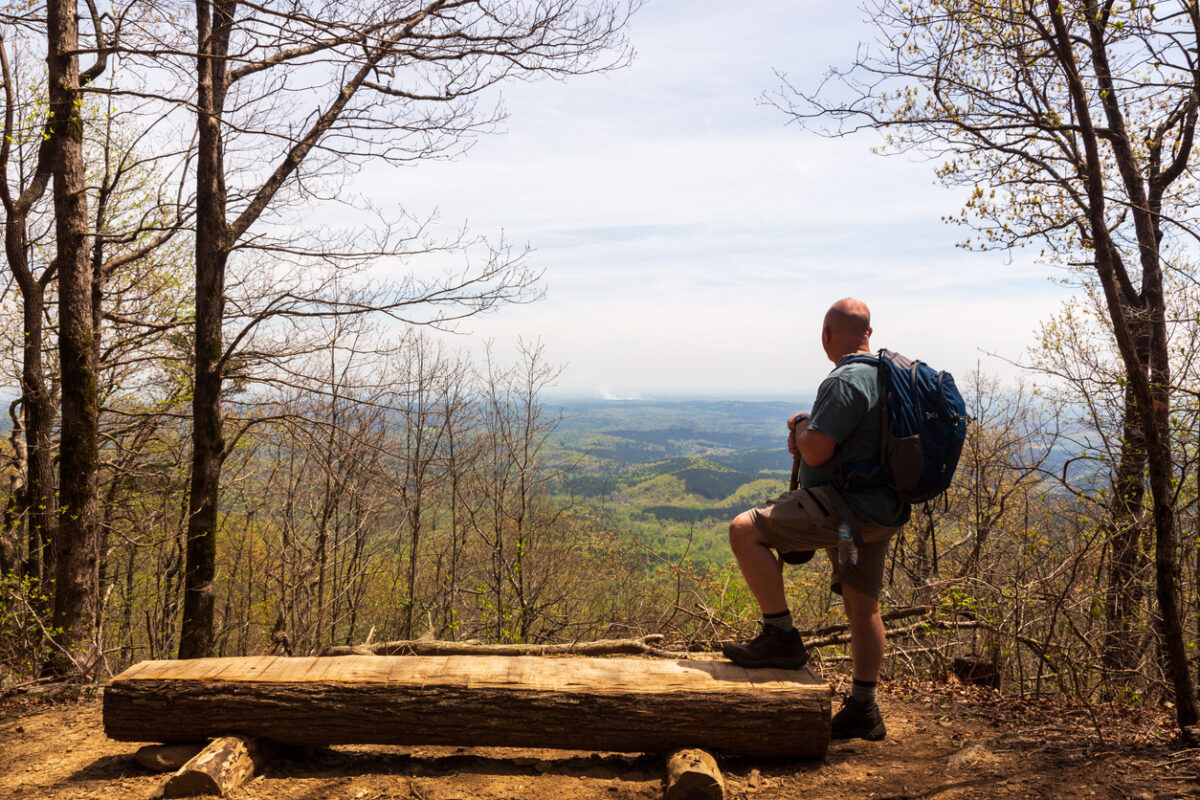 Hiker on a mountain trail at overlook viewing the Blue Ridge Mountains in the Chattahoochee National Forest.