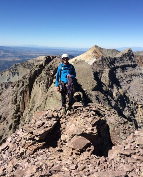 A climber on a peak in the San Juan mountains