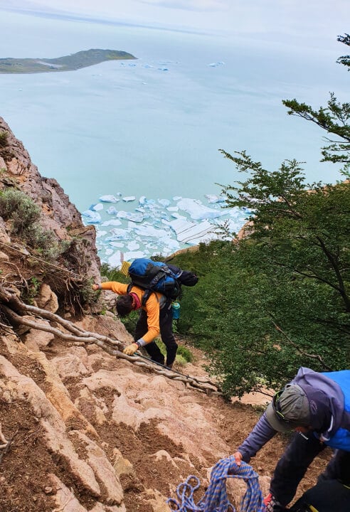 Hikers scrambling on the Huemul trek.