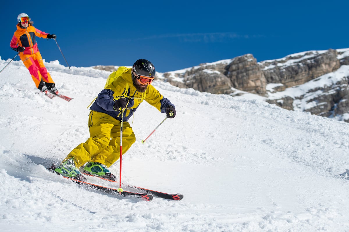 Two skiers downhill in Dolomites