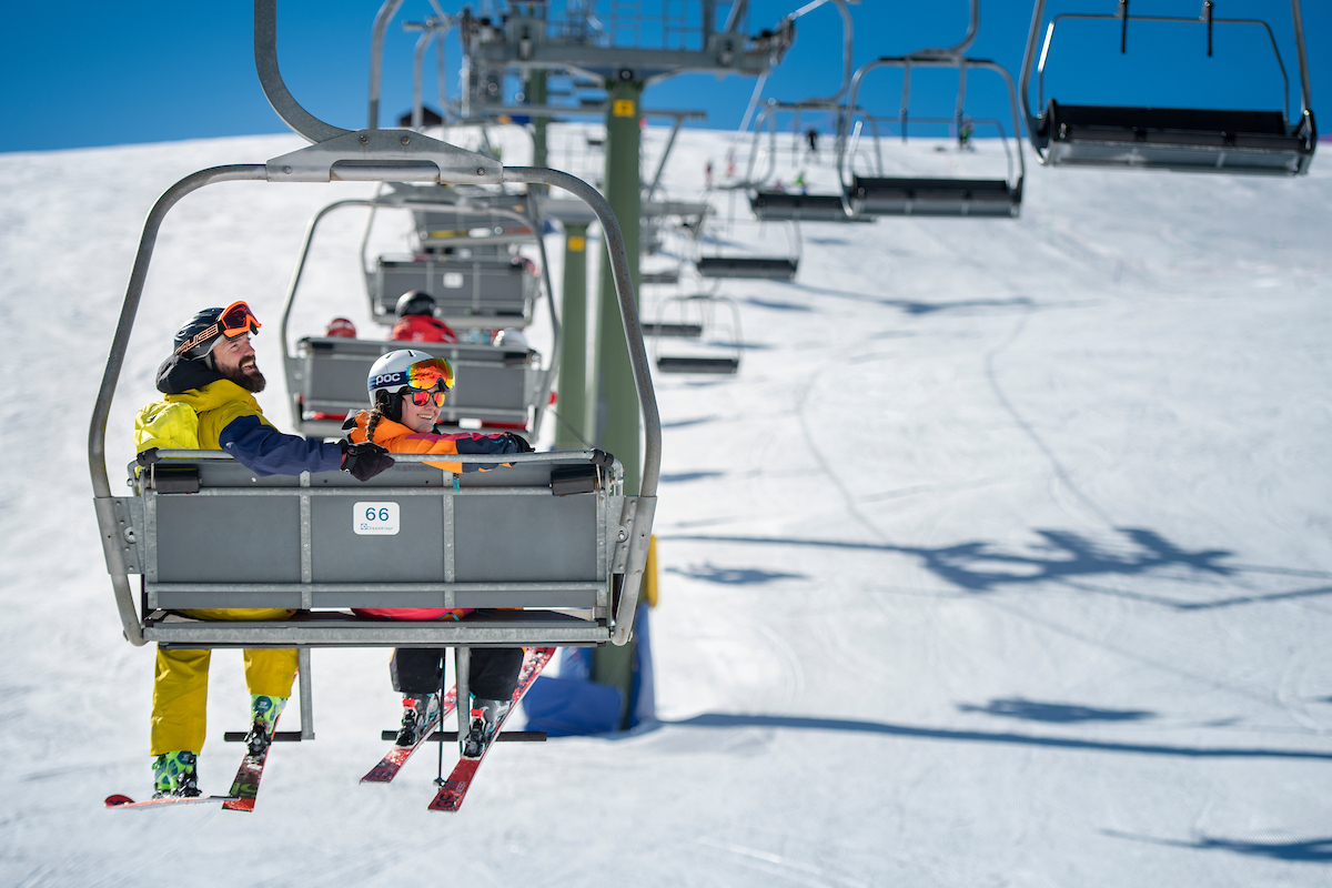 Two skiers lift Dolomites