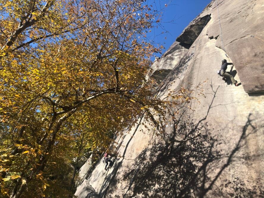 A rock climber works through the endurance crux on Frosted Flake 5.9+ on the Cereal Buttress of Rumbling Bald in North Carolina