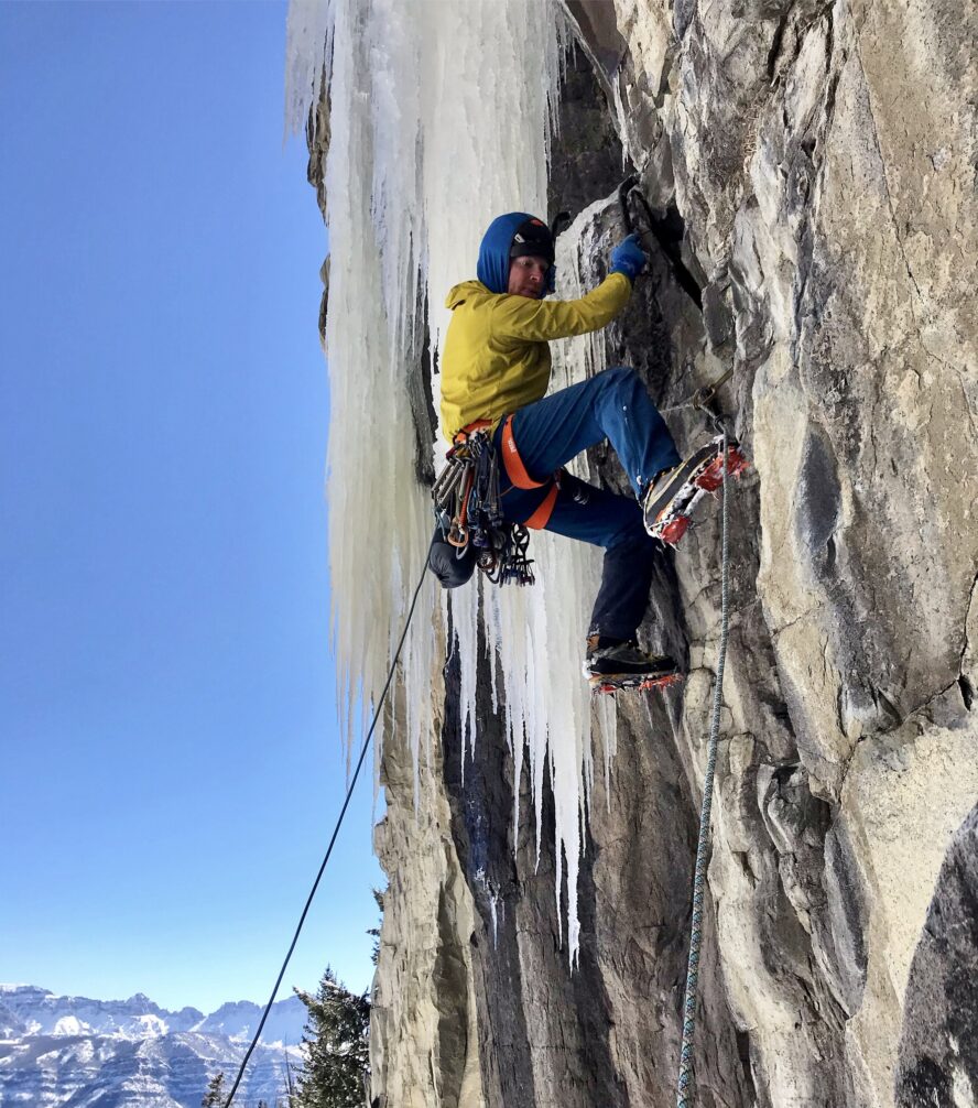 AMGA guide, Micah Lewkowitz, climbs mixed terrain on a route in Cody, Wyoming