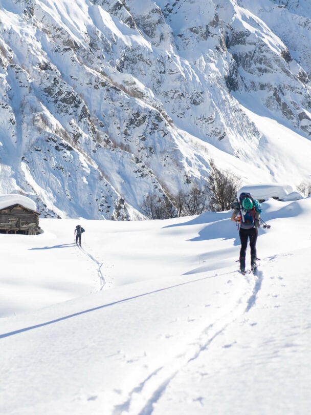 A lofty sniw-dusted mountain peak in the Georgian region of racha traversed by backcountry skiers