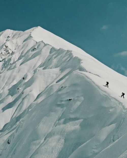 A lofty sniw-dusted mountain peak in the Georgian region of racha traversed by backcountry skiers