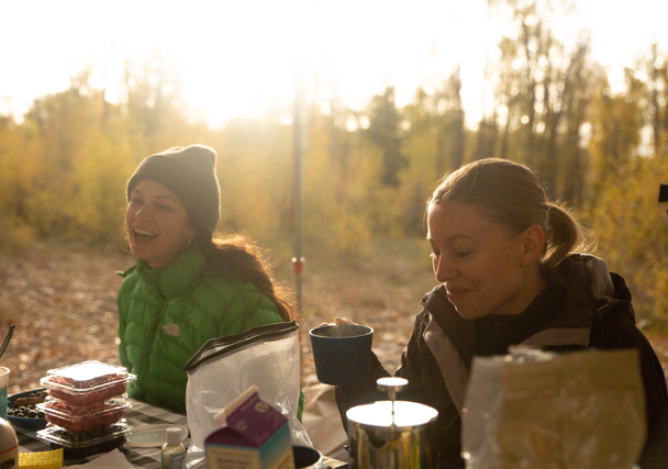 Couple relaxing and enjoying beautiful view of hot spring on vacation hiking trip. Beautiful Yellowstone Lake in the background and hot spring in foreground. Yellowstone National Park. Wyoming, USA